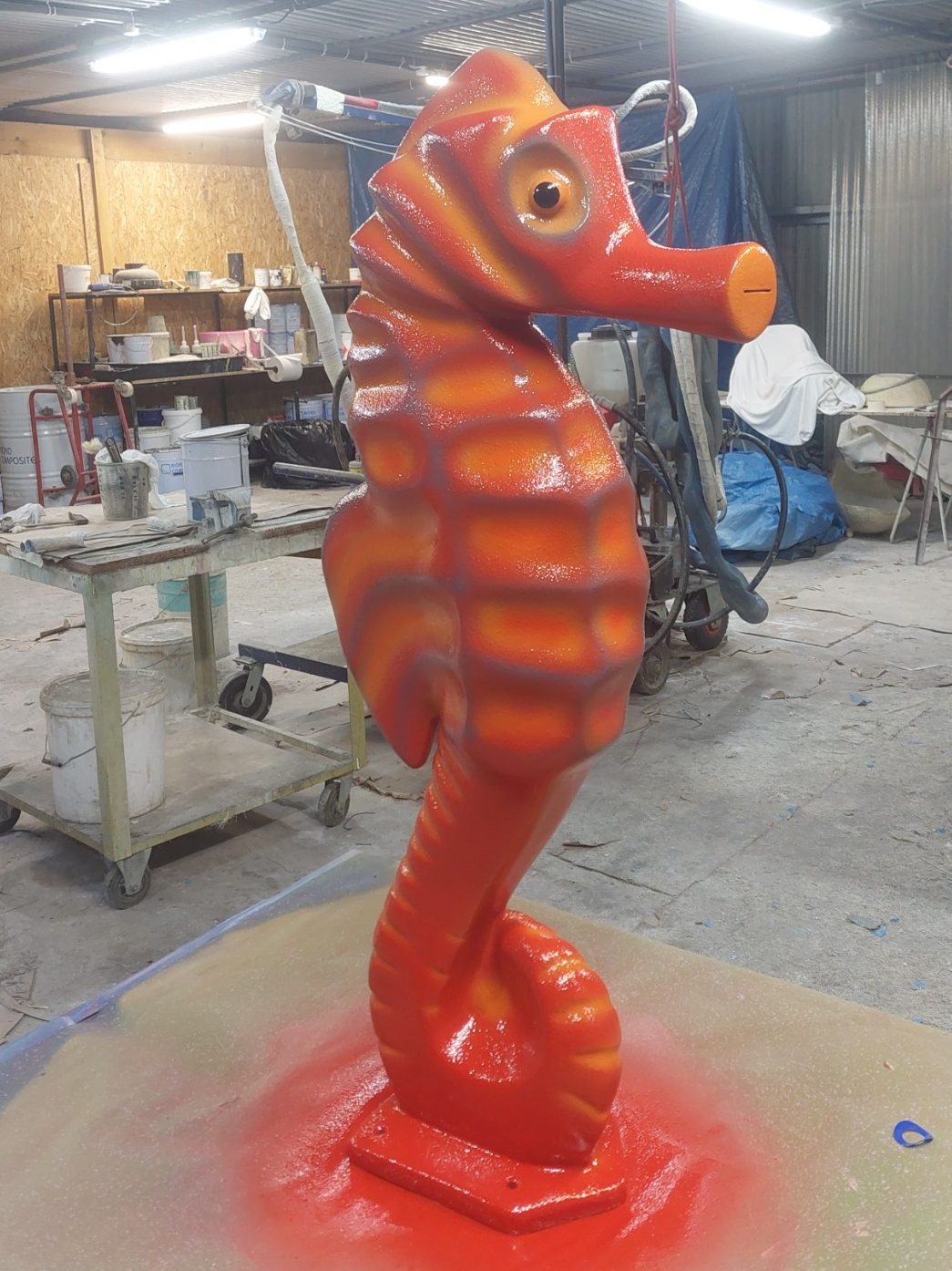 pièce aquatique en polyester peinture et déco à l'aérographe Sculpture d'un hippocampe orange en position verticale.