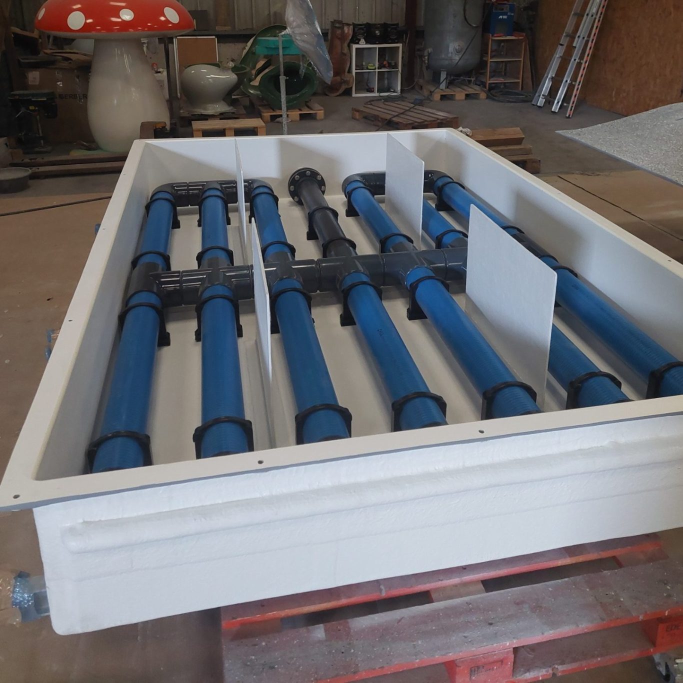 intallation du système de filtration pour eau de mer Réservoir blanc avec des tubes bleus pour le transport de fluides.